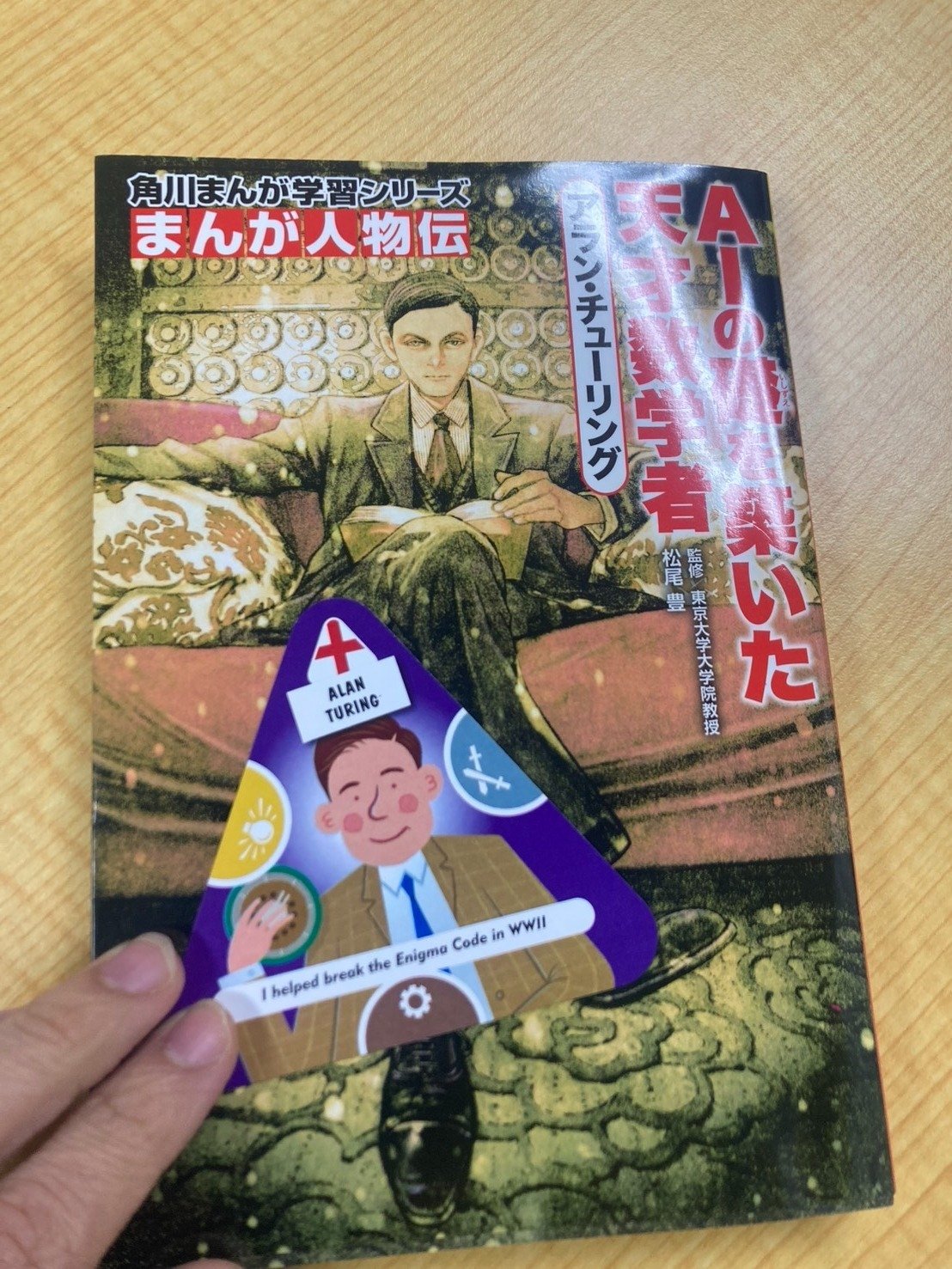 人物伝の本と三角形のカード